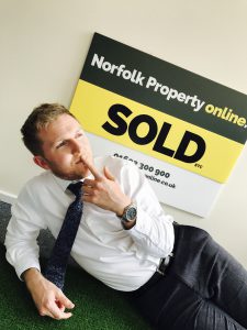Dan, a Norfolk Property Online agent, posing in front of a Norfolk Property Online 'for sale' board 